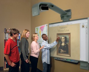 A group of students lined up and far too happy to be using a smartboard